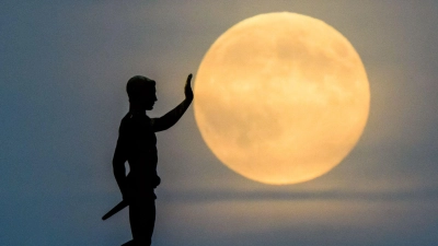 Der „Fackelträger” aus Hannover schiebt den Mond an.... (Foto: Julian Stratenschulte/dpa)