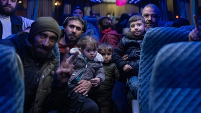 Menschen, die während des Bürgerkrieges in Syrien vertrieben wurden, kehren in Damaskus mit dem Bus nach Hause zurück. (Foto: Mosa'ab Elshamy/AP/dpa)