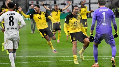 Die Dortmunder Spieler stürmen auf Elfmeter-Held Kobel zu. (Foto: Arne Dedert/dpa)