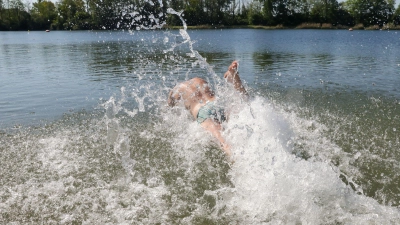 Wetter in Baden-Württemberg: Ein Mann springt im Sonnenschein in den sechzehn Grad warmen Schwarzachtalsee. (Foto: Thomas Warnack/dpa)