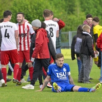 Ziemlich bedröppelt saß Weigenheims Kapitän Florian Eisenhut am letzten Spieltag 25/26 nach dem Schlusspfiff auf dem Rasen. Hinter ihm jubeln die Arberger, die 2:1 gewannen und so noch Platz 2 erklommen. (Foto: Martin Rügner)