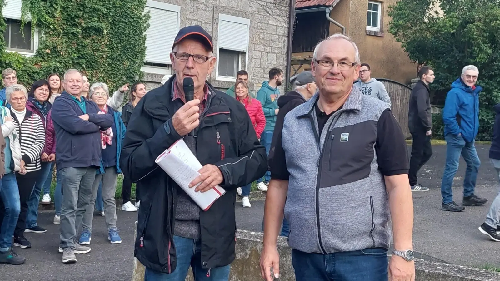  Rund 120 Personen nahmen an der Dorfführung in Herrnberchtheim teil. Die machten Paul Markert mit dem Mikrofon in der Hand und Andreas Zobel. Nachdem Letztgenannter vieles über die Kirche erzählt hatte, spielte er noch ein Lied auf der Kirchenorgel vor. (Foto: Christina Alt)