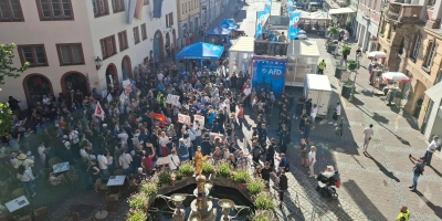 Auf dem Martin-Luther-Platz sind AfD-Vertreter (hinten) und Gegner (vorne) nur durch eine Absperrung am Hauseck getrennt. Es bleibt bei hitzigen Wortwechseln, die Polizei hat die Lage im Griff. (Foto: Alexander Biernoth)
