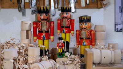 Historische Nussknacker und der Mini-Nussknacker „Willhelm“, der 2021 auf der Internationalen Raumstation ISS zu Gast war, stehen in der Werkstatt von Holzspielzeugmacher Markus Füchtner in Seiffen.  (Foto: Hendrik Schmidt/dpa)