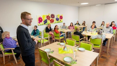 Dekan Max von Egidy begrüßte zum ersten Mittagessen im Rahmen des „Wärmewinters” im Gerlach-von-Hohenlohe-Stift. Unter dem Blumenbild sitzend ist Pfarrerin Heidi Wolfsgruber zu sehen, welche die Gesamtkoordination innehat. (Foto: Mirko Fryska)