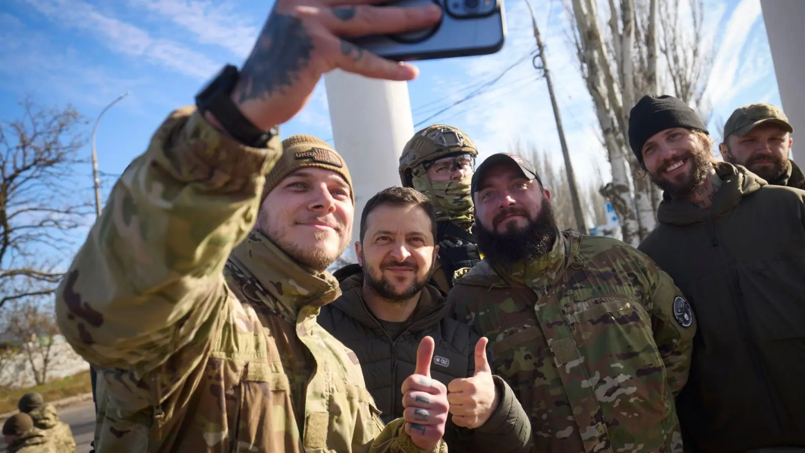 Ukrainische Soldaten machen ein Selfie mit Wolodymyr Selenskyj während seines Besuchs in Cherson. (Foto: ---/Ukrainian Presidential Press Office/AP/dpa)