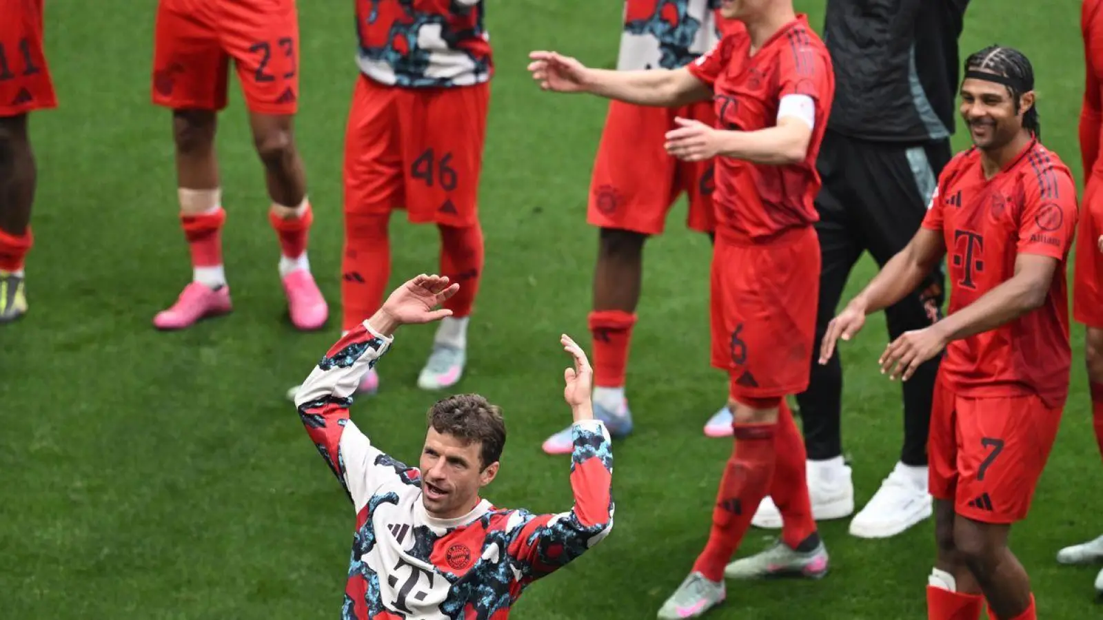 Thomas Müller (vorne) stimmte nach dem 3:3 in Leipzig die Welle mit den Fans an. (Foto: Hendrik Schmidt/dpa)