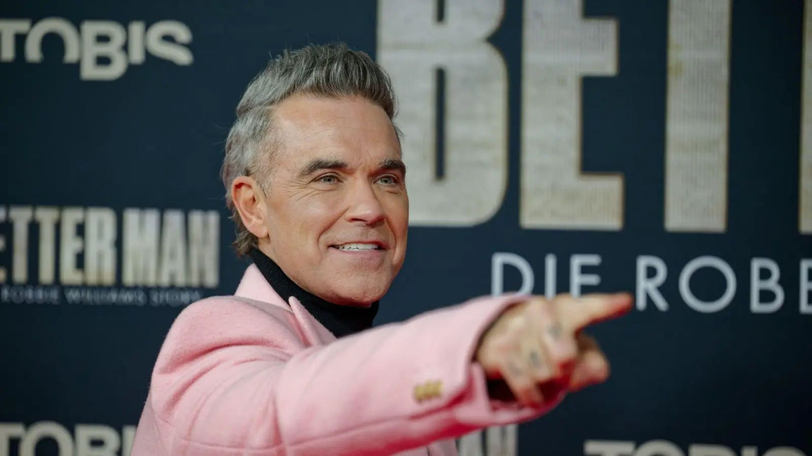 Robbie Williams kommt winterlich gekleidet zur Deutschland-Premiere seines Biopics. (Foto: Henning Kaiser/dpa)