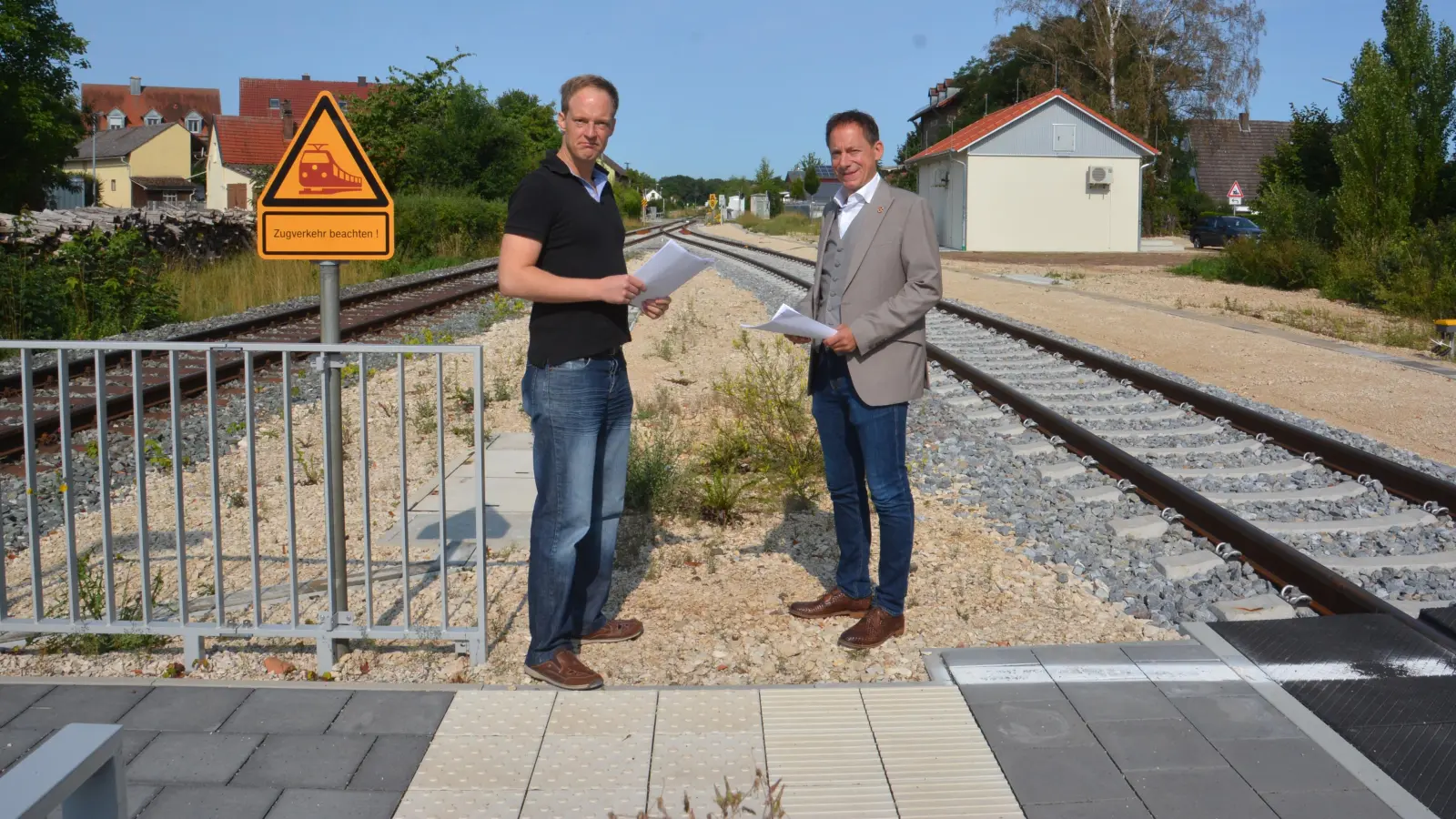 Das Begegnungsgleis ist fertig, das Stellwerk (im Hintergrund) auch. Peter Banczyk (links) von der „Verbindung zwischen Freunden“ und Wassertrüdingens Bürgermeister Stefan Ultsch (rechts) wundern sich nur noch über die Zeitverzögerungen. (Foto: Peter Tippl)