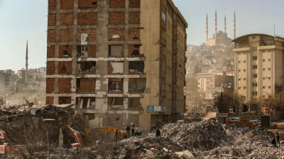 Menschen stehen im türkischen Kahramanmaras auf den Trümmern eines eingestürzten Gebäudes. (Foto: Emrah Gurel/AP/dpa)