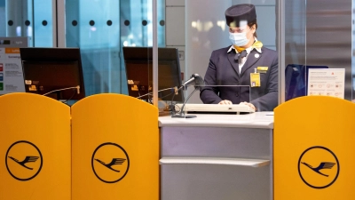 Eine Mitarbeiterin der Lufthansa bereitet am Flughafen München das Boarding für einen Flug vor. (Foto: Sven Hoppe/dpa)