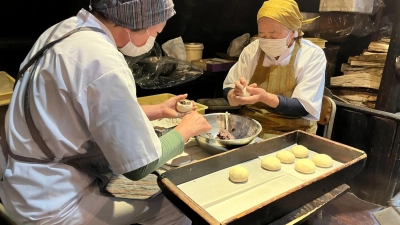 Harumi Okubo (79, rechts) und ihre Kollegin Tomoko Horiuchi (58) beim Oyaki-Backen in einem Restaurant, wo sie arbeiten. (Foto: Lars Nicolaysen/dpa)