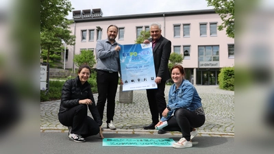 Das Team der Wirtschaftsförderung am Landratsamt, bestehend aus Julia Tschawdarow (links unten), Claus Seifert (rechts stehend), Michael Capek und Stefanie Binder, präsentiert das Plakat für die erste Neustädter Expo.  (Foto: Patrick Lauer)