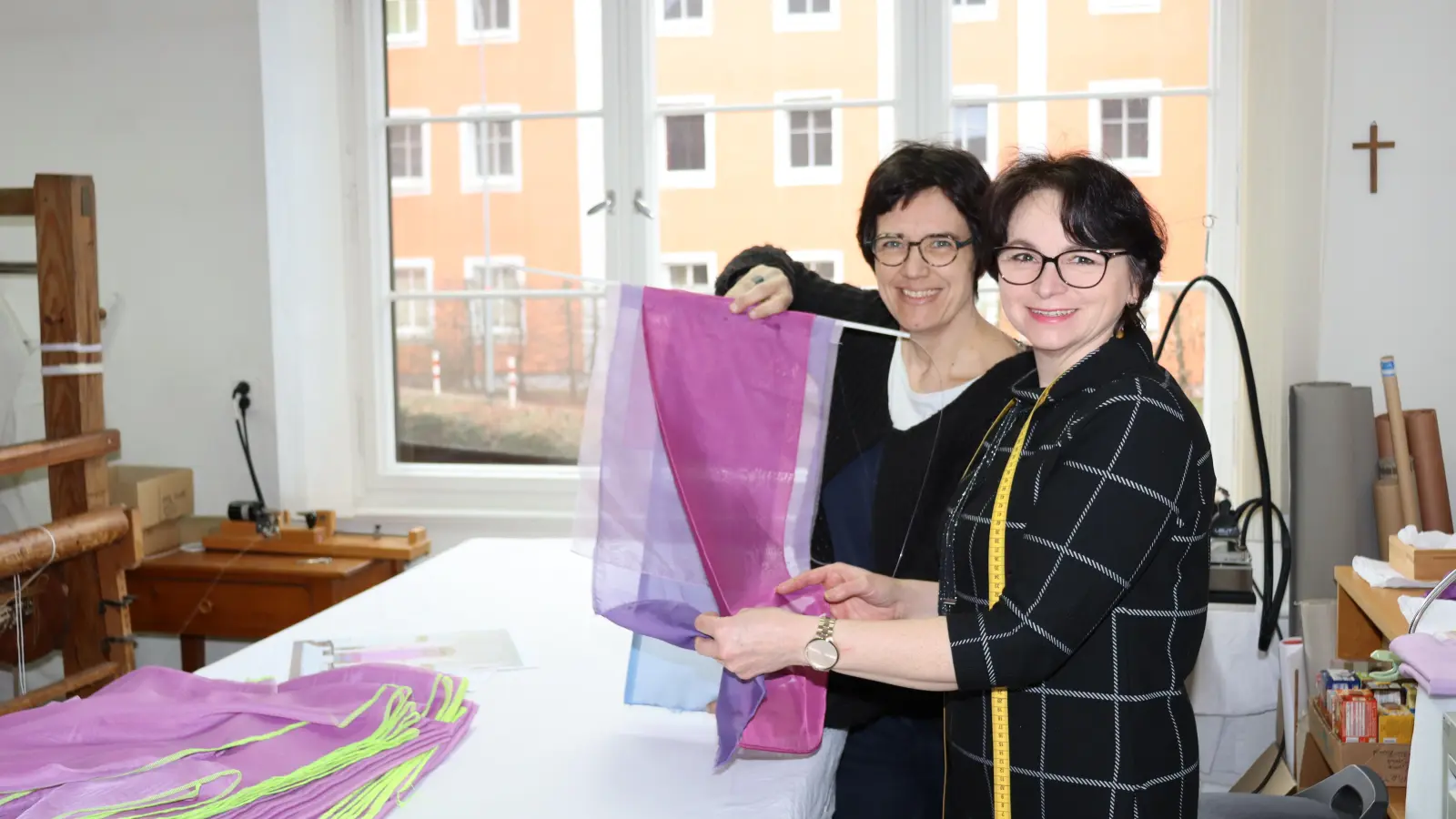 Beate Baberske und Rosalia Penzko von der Diakoneo Paramentik Neuendettelsau zeigen ein Muster des Fastentuchs für die Jesuitenkirche in Heidelberg. (Foto: Thomas Schaller)