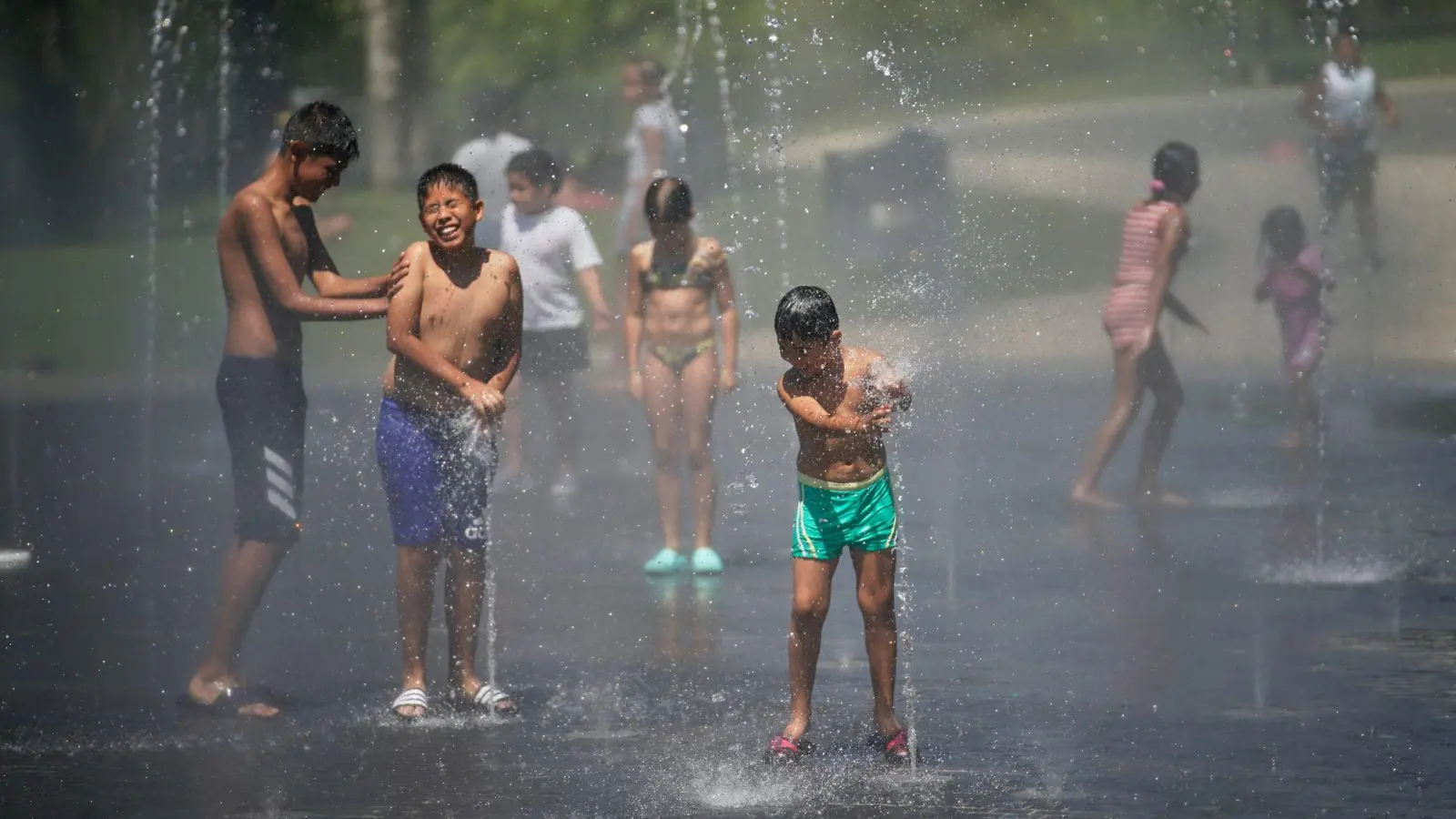 Kinder suchen Abkühlung in der spanischen Hauptstadt Madrid. (Archivbild) (Foto: Andrea Comas/AP/dpa)