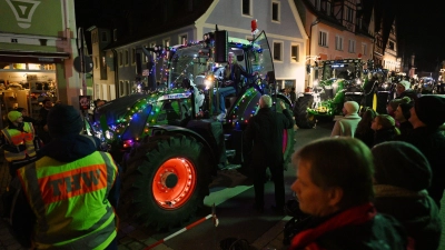 Der Lichterzug schlängelte sich am Freitagabend durch Neustadt. Bürgermeister Klaus Meier (an der Traktortür) dankte den Teilnehmerinnen und Teilnehmern mit einem kleinen Geschenk. (Foto: Mirko Fryska)