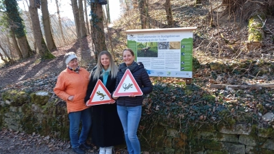 Erika Kemmether (links) von der Feuersalamandergruppe sowie Mareike Bialojan (rechts) und die Auszubildende Stefanie Miku vom städtischen Ordnungsamt bei der Übergabe der Hinweisschilder. (Foto: Walter Würfel)