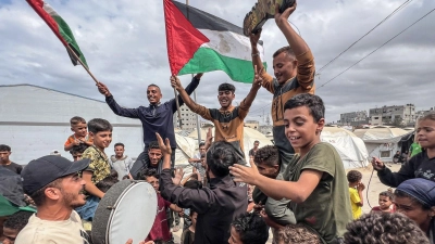 Palästinenser feiern im Lager Nusairat, nachdem sich Israel und die Hamas auf die erste Phase eines Friedensplans zur Beendigung der Kämpfe geeinigt haben. (Foto: Belal Abu Amer/APA Images via ZUMA Press Wire/dpa)