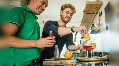 Freude am Experimentieren: Freunde bereiten in der heimischen Küche einen alkoholfreien Aperitif mit Sanbitter zu. Er ist für seine rote Farbe und bittersüße, herbe Geschmacksnote bekannt. (Foto: Christin Klose/dpa-tmn)