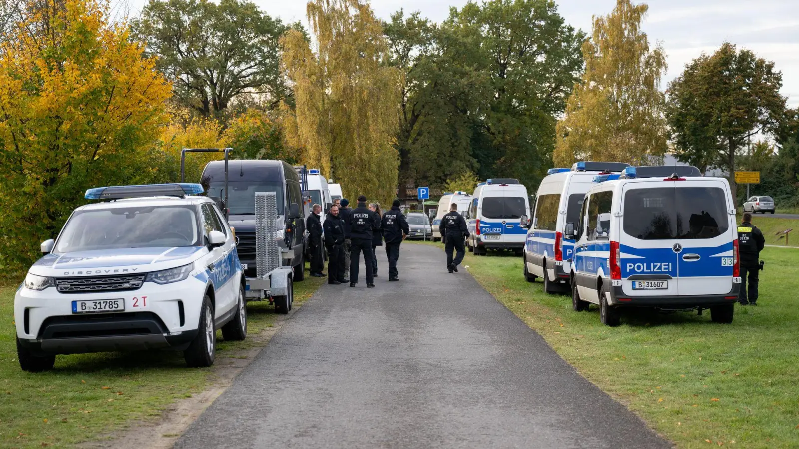 Polizeiautos stehen auf einer Wiese in Tauche.  (Foto: Christophe Gateau/dpa)