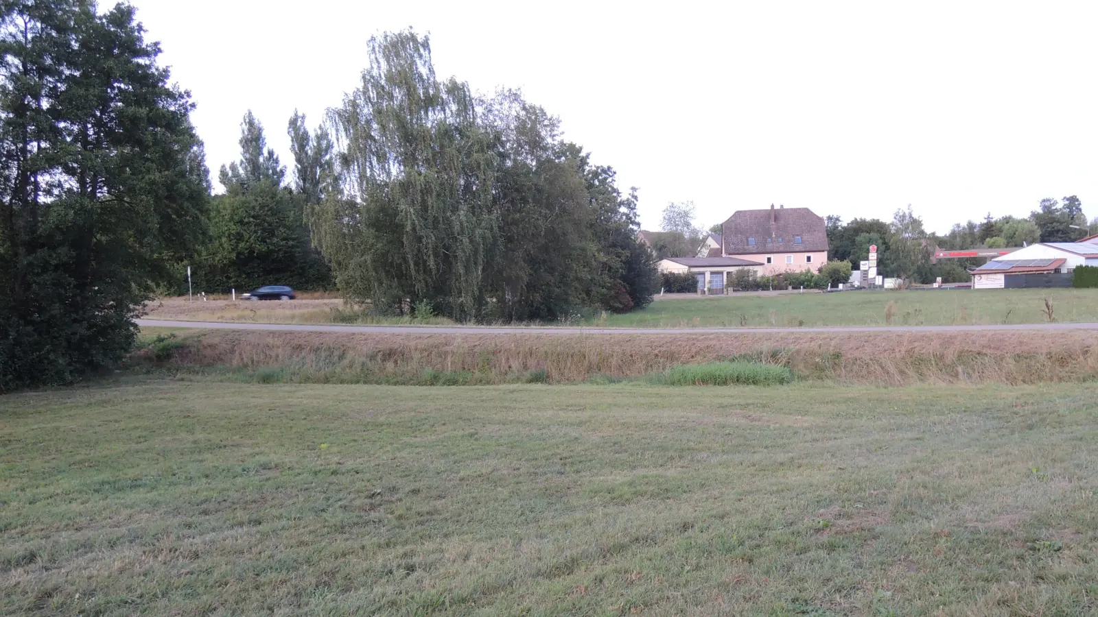 Die Problemzone bei Hochwasserereignissen in Dorfgütingen: Der Damm, auf dem die im Vordergrund zu sehende Straße verläuft, wird erhöht, damit bei Starkregen die Fluten künftig nicht mehr die Bundesstraße 25 im Bereich der Tankstelle überschwemmen. (Foto: Peter Zumach)