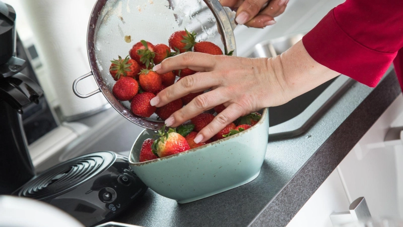 Bleibt der Strunk beim Waschen der Erdbeeren dran, wird der Geschmack nicht verwässert. (Foto: Christin Klose/dpa-tmn)