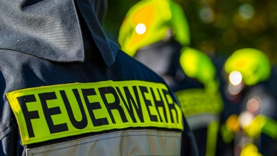 Feuerwehrleute stehen zusammen, um den Einsatz zu besprechen. (Foto: David Inderlied/dpa/Symbolbild)