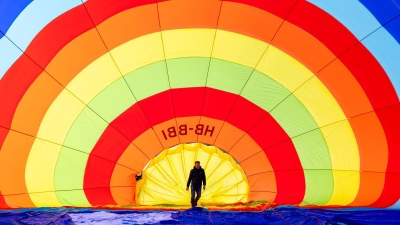 Ein Teammitglied überprüft seinen Heißluftballon vor dem Start während des 46. Internationalen Heißluftballon-Festivals in Chateau-d'Oex. (Foto: Cyril Zingaro/KEYSTONE/dpa)