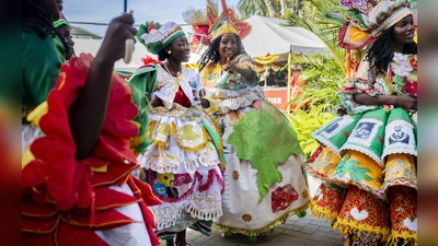 Bunt gekleidete Gäste feiern im Garten des Präsidentenpalastes von Suriname. (Foto: Remko De Waal/ANP/dpa)