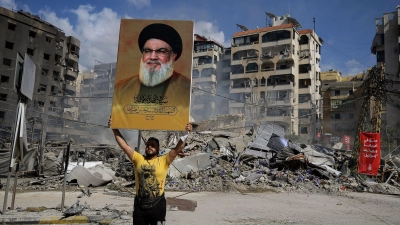 Ein Anhänger mit einem Poster des getöteten Hisbollah-Generalsekretärs Nasrallah. (Foto: Marwan Naamani/dpa)