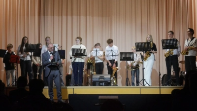 Schulleiter Wolfram Schröttel vor der schulischen Big Band bei seinen einleitenden Worten zur Jubiläumsfeier in der Wolfgang-Graf-Halle – eine kleine Spitze gegen den Bürgermeister hatte er dabei auch noch im Gepäck.  (Foto: Martina Hinkelmann)