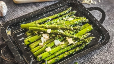 Mit Parmesan, Chiliflocken oder Balsamico-Creme verfeinert, lässt sich der gegrillte grüne Spargel pur, als Beilage oder mit einem leckeren Dip genießen. (Foto: Anja Würfl/die-frau-am-grill.de/dpa-tmn)