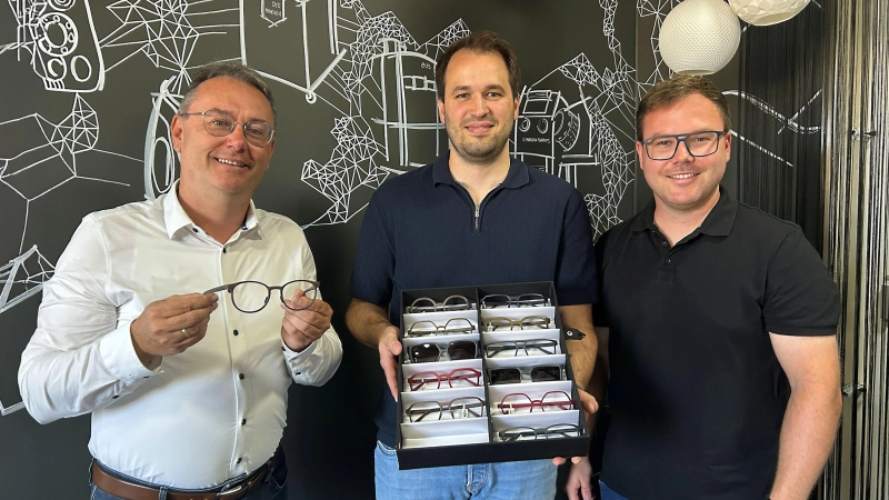 Der Vorsitzende der Lokalen Aktionsgruppe Region an der Romantischen Straße, Feuchtwangens dritter Bürgermeister Herbert Lindörfer, ließ sich von Alexander Bahle (rechts) und Tim Riedmüller (Zweiter von rechts) die Brillenkollektion zeigen.  (Foto: LAG/Julia Ploch)