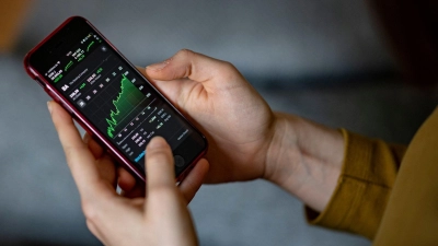 Mit Apps wie „Trade Republic” lässt sich per Smartphone an der Börse handeln. Jetzt kursiert eine Betrugsmasche. (Symbolbild: Fabian Sommer/dpa)