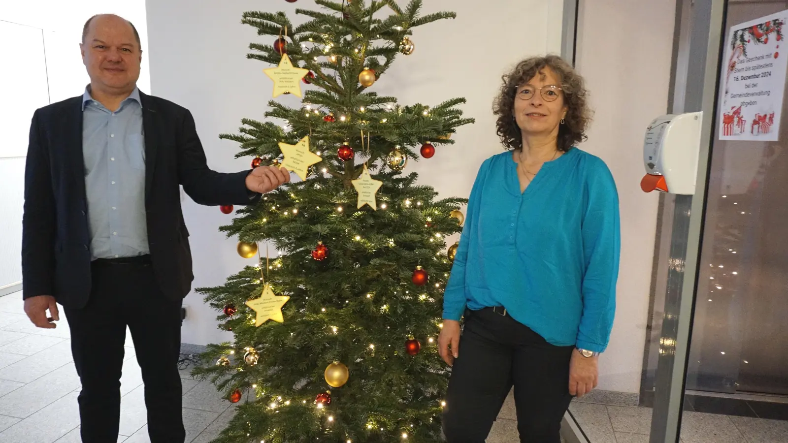 Freuen sich, dass der Wunschbaum so gut ankommt: Sachsens Bürgermeister Bernd Meyer und Dagmar Kojellis aus der Verwaltung. Für das Foto wurden noch einmal einige Sterne aufgehängt. (Foto: Andrea Walke)