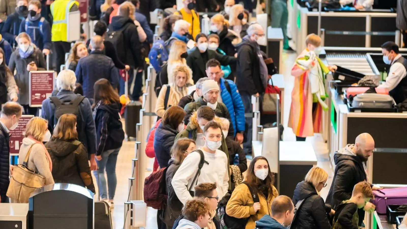 Passagiere stehen am Flughafen Berlin Brandenburg (BER) vor der Sicherheitskontrolle Schlange (Archivbild). (Foto: Christoph Soeder/dpa)