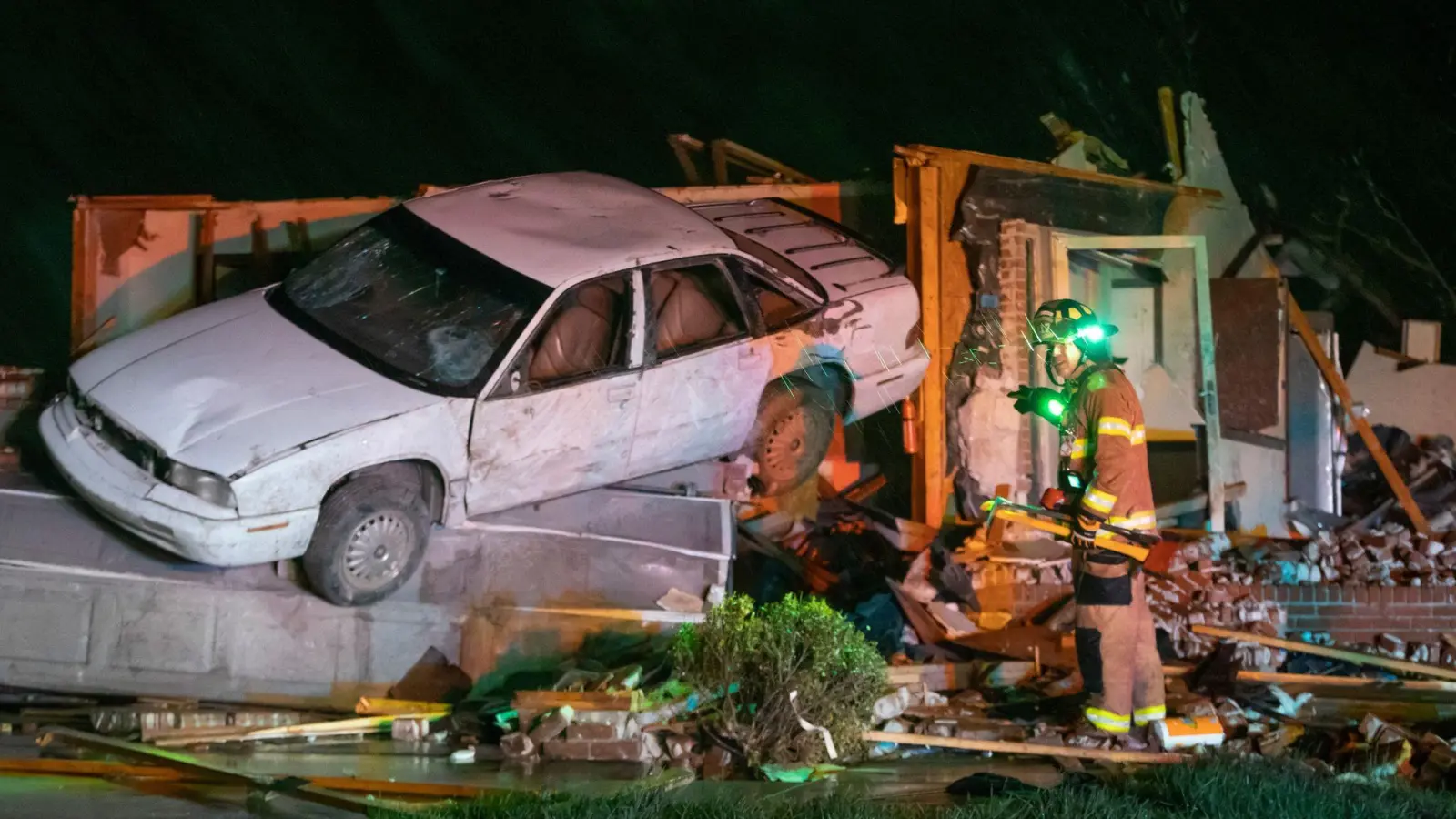 Ein Feuerwehrmann aus Wichita steht vor einem stark beschädigten Auto und Haus in Andover, nachdem ein Tornado durch das Gebiet östlich von Wichita gezogen ist. (Foto: Travis Heying/The Wichita Eagle/AP/dpa)