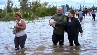 Bewohner waten durch überflutete Straßen nach heftigen Regenfällen in Campana, Argentinien. (Foto: Rodrigo Abd/AP/dpa)