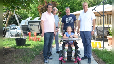 Die Lions Neustadt mit Armin Feuchtmann, Dr. Josef Stauber, Vater Markus Lux sowie Lions-Präsident Oliver Zeilinger und das Mädchen mit Behinderung Tina (von links) beim Besuch auf dem Grundstück in Dagenbach. Dort wurde der Weg für Tina barrierefrei gepflastert. (Foto: Christa Frühwald)