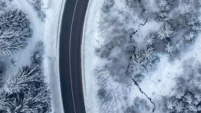 Ein Auto fährt auf einer Landstraße durch den winterlichen Wald im Vogtland. (Foto: Jan Woitas/dpa)