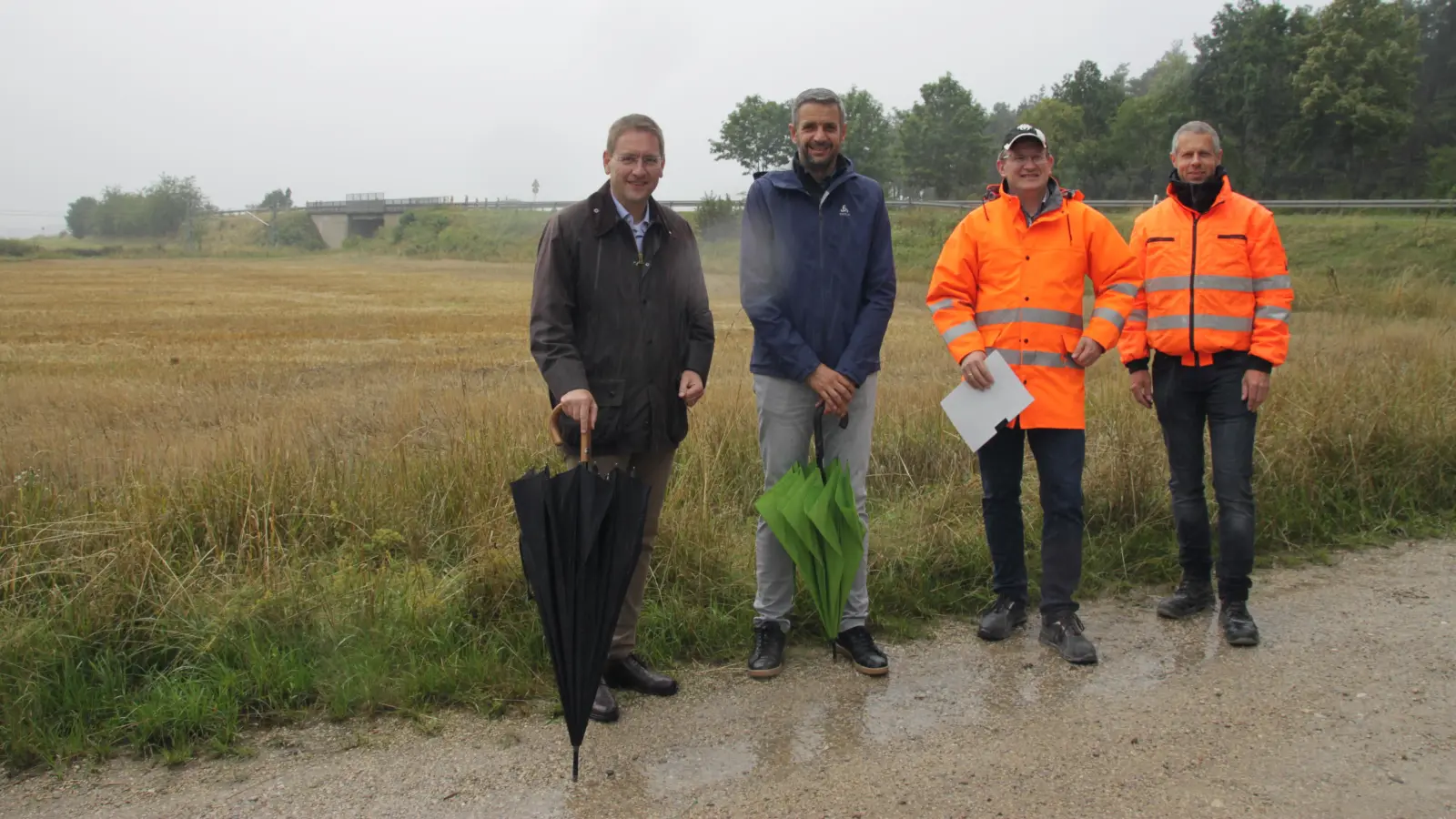 Die Bahnbrücke bei Großbreitenbronn im Hintergrund macht seit Jahren Probleme. Landrat Dr. Jürgen Ludwig, Merkendorfs Bürgermeister Stefan Bach sowie Abteilungsleiter Michael Schätzl und Projektleiter Oliver Stark (v. l.) freuen sich, dass sie nun endlich erneuert werden kann. (Foto: Robert Maurer)