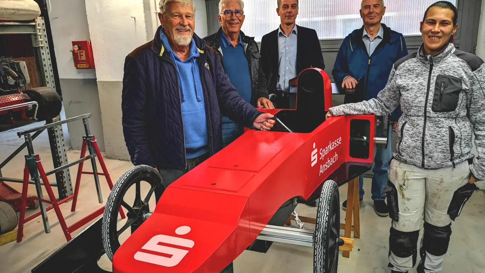 Der Motorsportclub ist in die Holzklasse eingestiegen. Das Foto zeigt Fahrzeugmalerin Mandy Braun und Konstrukteur Georg Krauß (von rechts) mit dem Ehrenvorsitzenden Siegberth Holter, Schatzmeister Peter Dinzl und Sponsorenvertreter Jürgen Rummel (von links) am roten Flitzer. (Foto: Jürgen Binder)