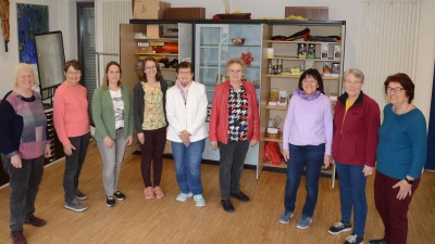 Mitarbeiterinnen des Eine-Welt-Ladens Maria Kaiml, Monika Grimm, Andrea Schmidt, Verena Müller, Inge Tauber, Christine Tippl, Heidi Krakowczyk, Claudia Herbst und Monika Titze (von links) im Katholischen Pfarrheim vor dem „Eine-Welt-Schrank“. (Foto: Peter Tippl)