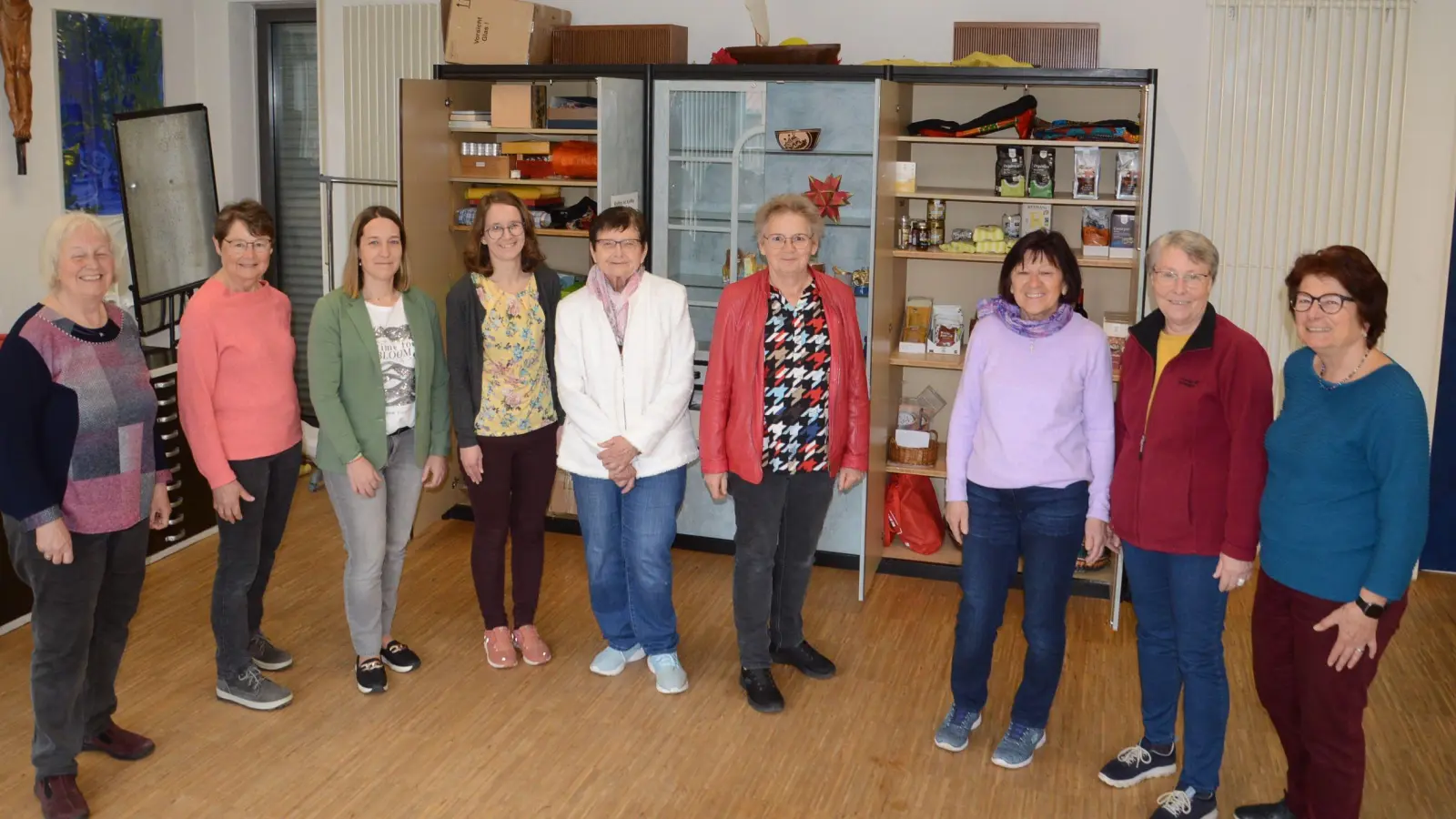 Mitarbeiterinnen des Eine-Welt-Ladens Maria Kaiml, Monika Grimm, Andrea Schmidt, Verena Müller, Inge Tauber, Christine Tippl, Heidi Krakowczyk, Claudia Herbst und Monika Titze (von links) im Katholischen Pfarrheim vor dem „Eine-Welt-Schrank“. (Foto: Peter Tippl)