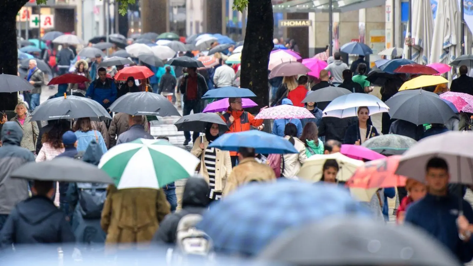 Passanten mit Regenschirmen laufen im Regen durch die Fußgängerzone Neuhauser Straße und Kaufingerstraße nahe dem Stachus in München. (Foto: Matthias Balk/dpa)