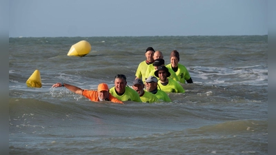 Bald ist es geschafft: die Gruppe gegen Ende des Meerwasserwanderns mit Erfinder Thomas Wallyn. (Foto: Andreas Drouve/dpa-tmn)