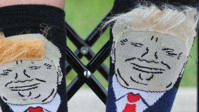 Extra Trump-Socken hat sich ein Kind angezogen, das auf die Ankunft des US-Präsidenten auf seinem Golfplatz in Schottland wartet. (Foto: Robert Perry/PA Wire/dpa)