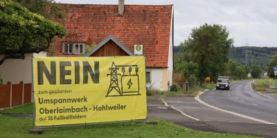 In Hohlweiler weisen zwei großformatige Transparente auf Widerstand gegen das geplante Umspannwerk beziehungsweise dessen Größe hin. (Foto: Andreas Reum)