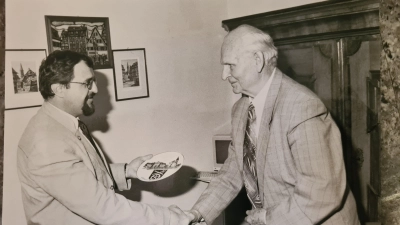 Philipp Hügel (rechts) erhielt 1997 als kleinen Dank in Erinnerung an seine Tat einen Wandteller der Gemeinde Illesheim vom damaligen Bürgermeister Heinrich Förster. (Repro: WZ-Archiv/Hildenstein)