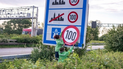Auf Autobahnen gilt ... ein Tempo-100-Tempolimit? So zumindest wollen es Greenpeace-Aktivistinnen, hier bei der Aktion am Montagmorgen in Aachen.  (Foto: Benjamin Westhoff/dpa)